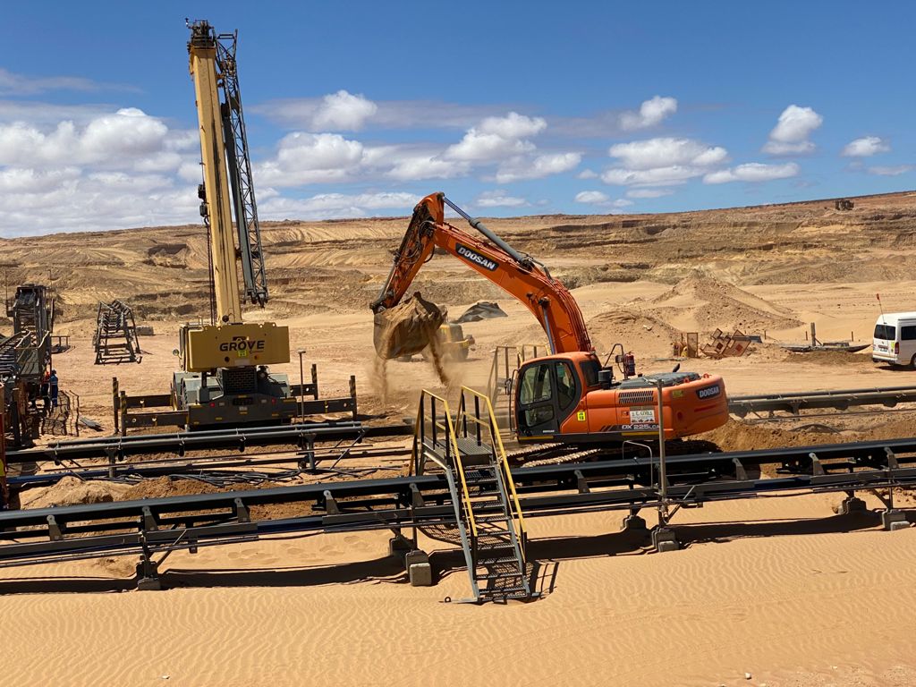 25T excavator installing deadman blocks on a mining site